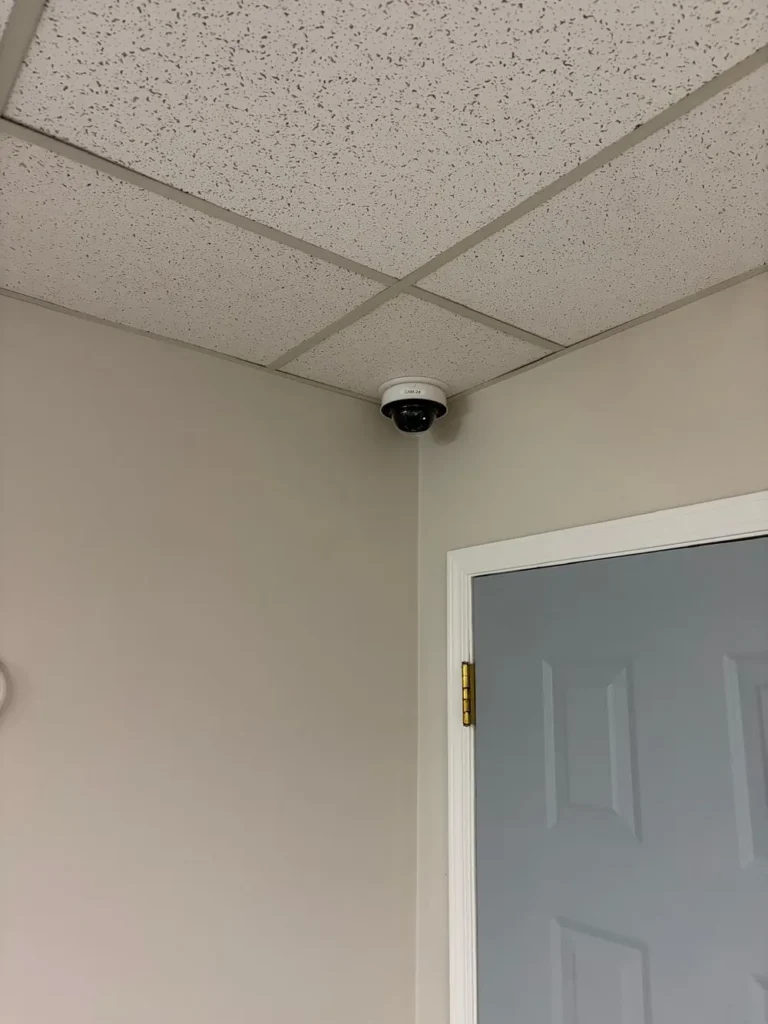 Dome camera in the corner of a ceiling above a door