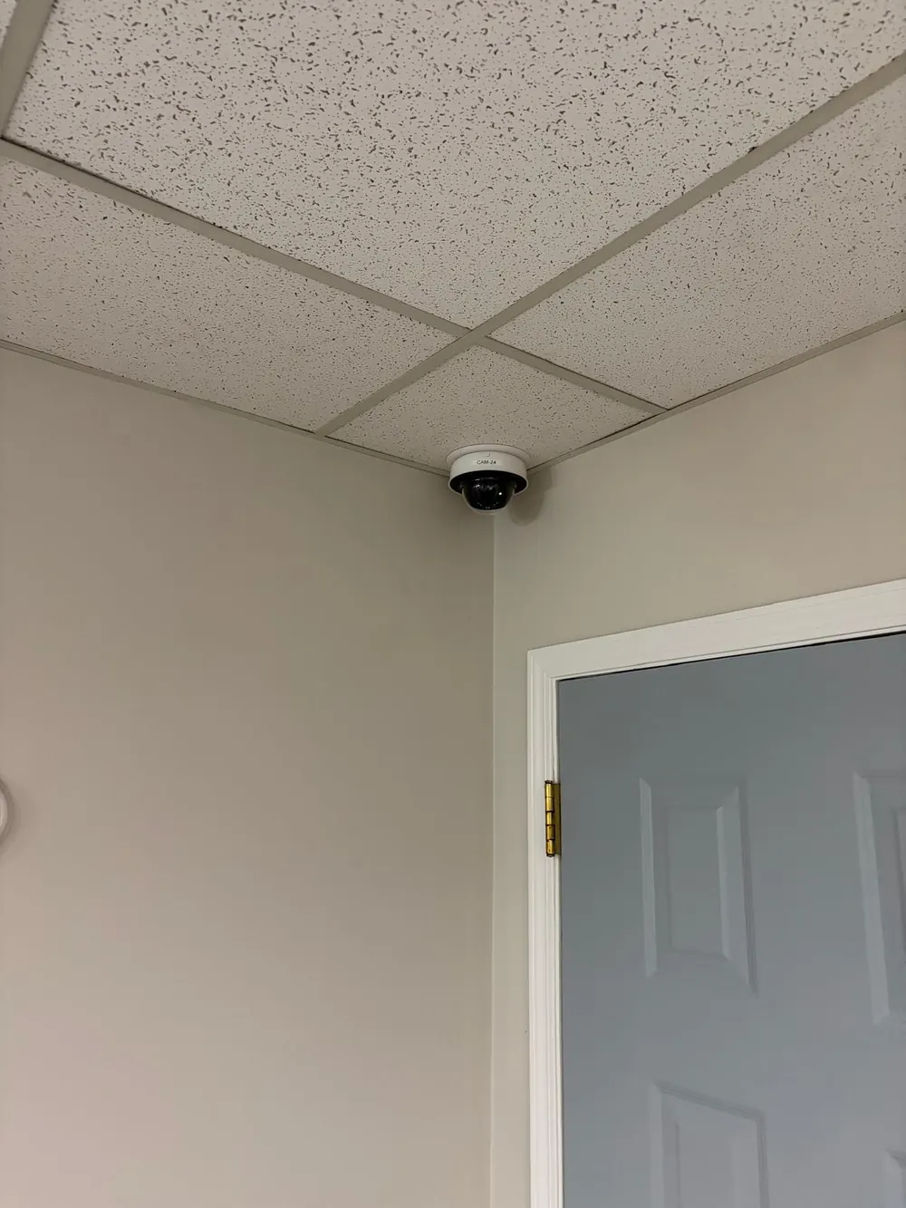Dome camera in the corner of a ceiling above a door