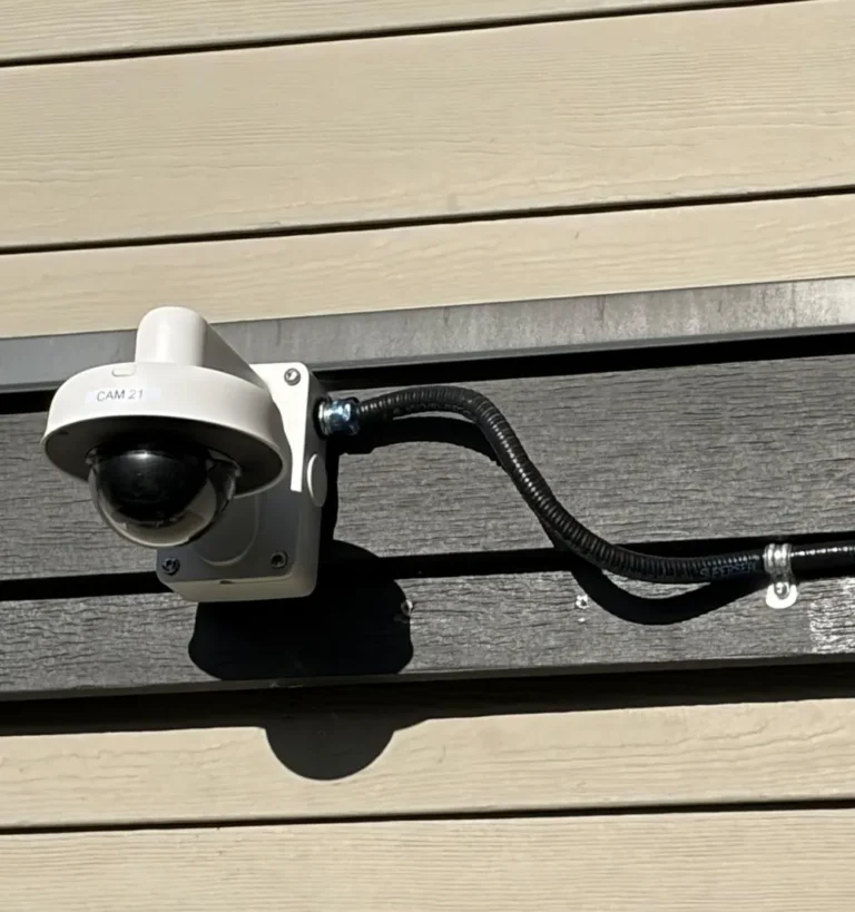 Outdoor dome camera with flexible conduit on siding