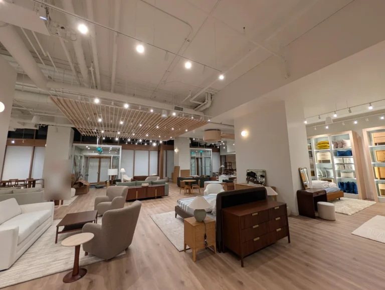 Furniture showroom with open ceiling, track lights, pendant speakers and dome cameras