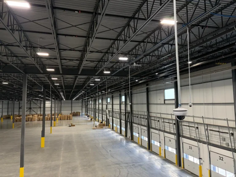 Large warehouse with cameras hanging on poles above the loading dock doors